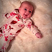 Olivia joined the competition — help win amazing prizes! baby, infant, smile, face, onesie, red_bows, blanket, soft_texture, lying_down, cute, happy, child, cozy, indoors, portrait, skin, head, hand, expression, newborn