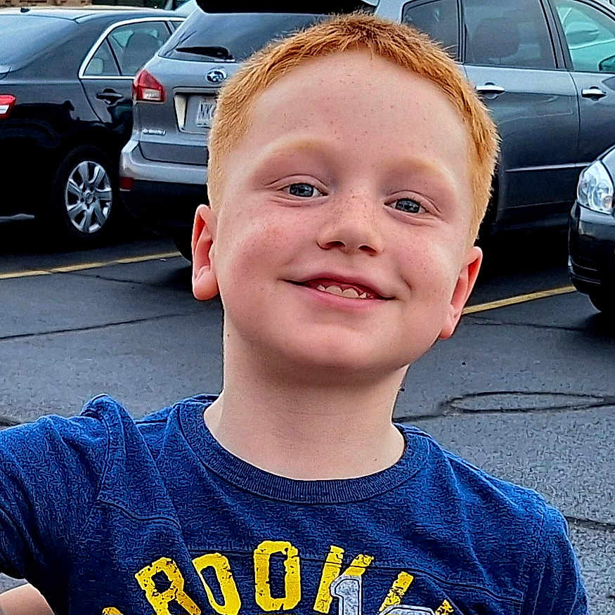 Truman joined the competition — help win amazing prizes! asphalt, blue_shirt, boy, cars, casual_clothing, child, daylight, face, freckles, happy, outdoor, parking_lot, people, person, portrait, red_hair, road, smile, street, vehicle