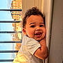 toddler, child, smiling, curly_hair, white_shirt, window, sunlight, indoor, face, happy, cute, portrait, baby, cheerful, young_child, skin, expression, person, daylight, home