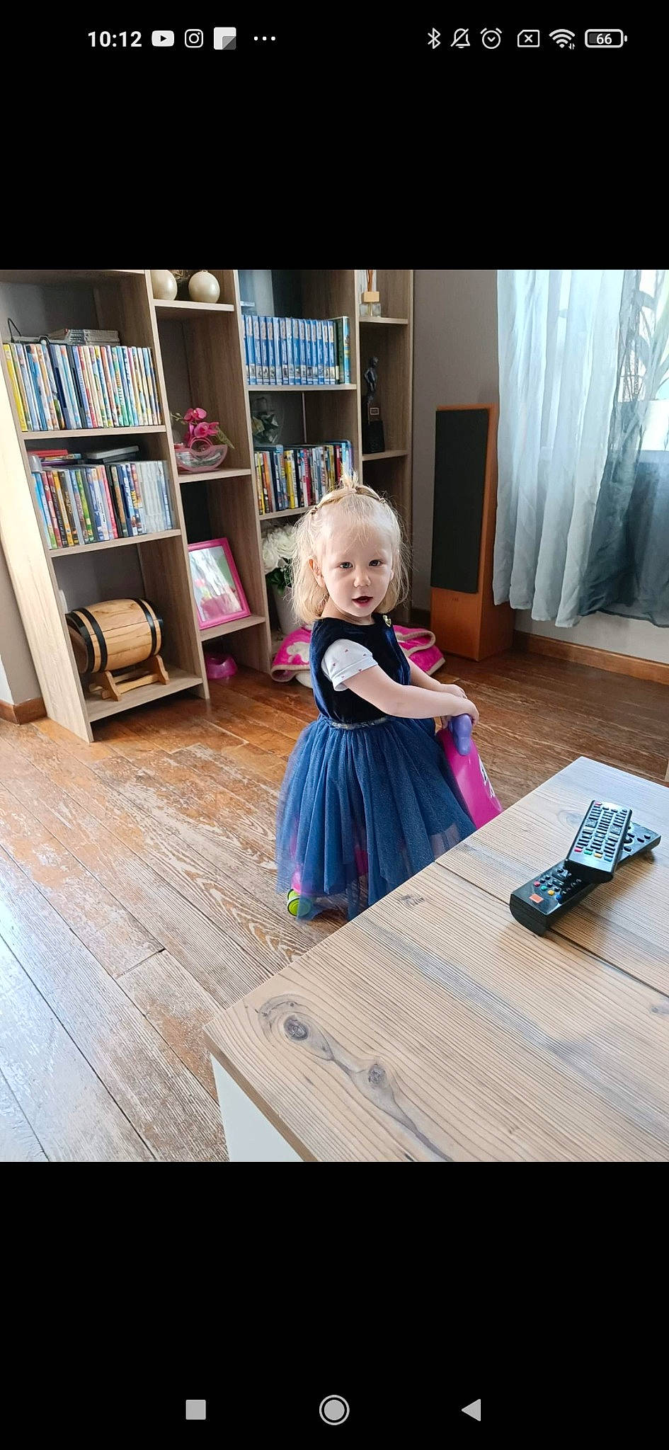 Iris a rejoint le concours — aidez-le/la à gagner de superbes lots ! baby_toddler_clothing, book, bookcase, child, curtain, floor, flooring, hardwood, house, interior_design, laminate_flooring, magenta, person, purple, shelf, shelving, toddler, violet, window, wood