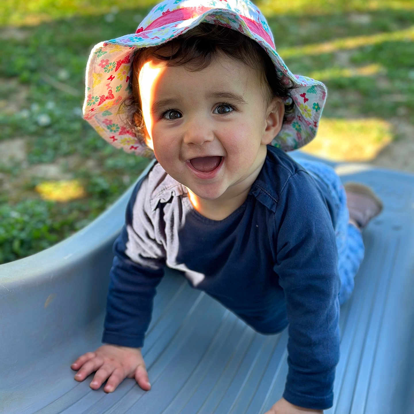 Mya a rejoint le concours — aidez-le/la à gagner de superbes lots ! baby, clothing, crawling, face, grass, hat, head, nature, outdoorplayarea, outdoors, pants, park, person, photography, plant, playarea, portrait, slide, sunhat, toy