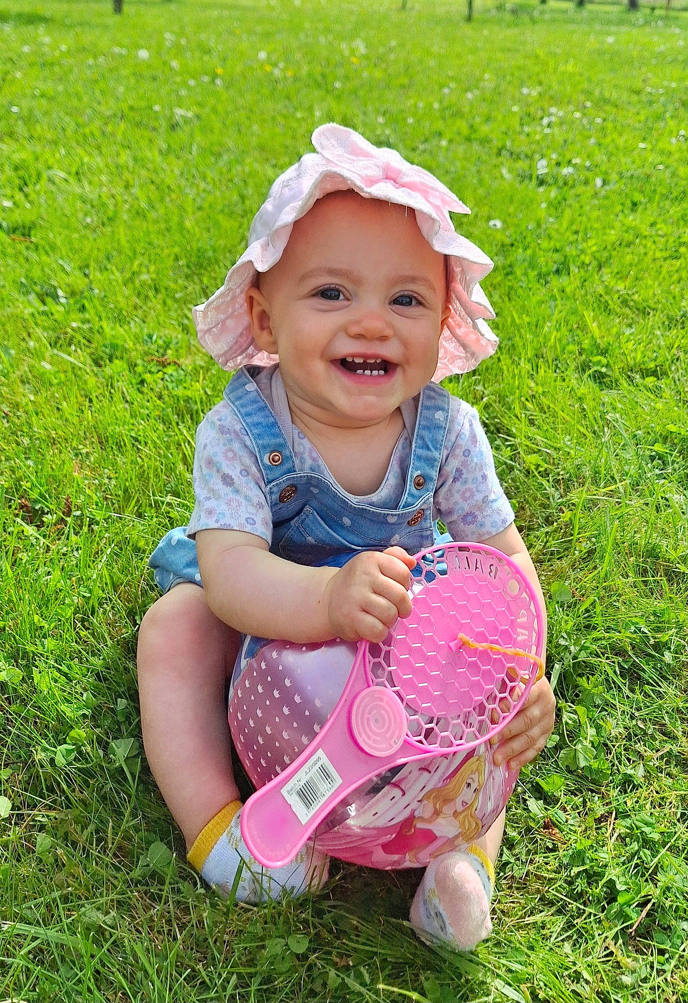 Séréna a rejoint le concours — aidez-le/la à gagner de superbes lots ! baby, baby_toddler_clothing, child, dress, eye, facial_expression, fun, grass, green, hand, happy, headwear, joy, mammal, meadow, people_in_nature, person, pink, plant, skin