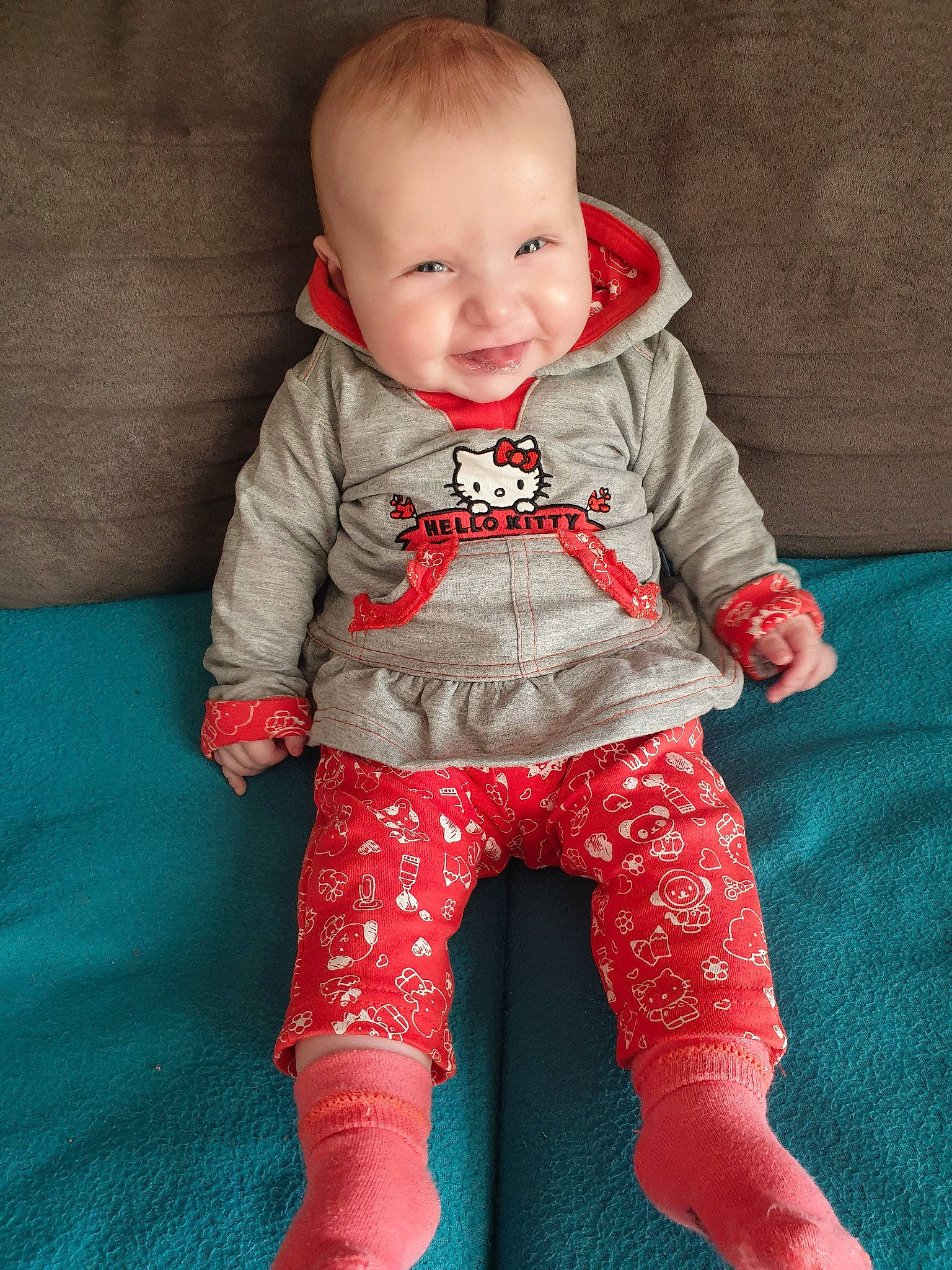 Ayana participe au concours pour gagner de l'argent avec cette photo : baby, baby_toddler_clothing, cheek, child, child_model, face, footwear, head, outerwear, pajamas, person, pink, red, shoe, sitting, skin, sleeve, standing, toddler