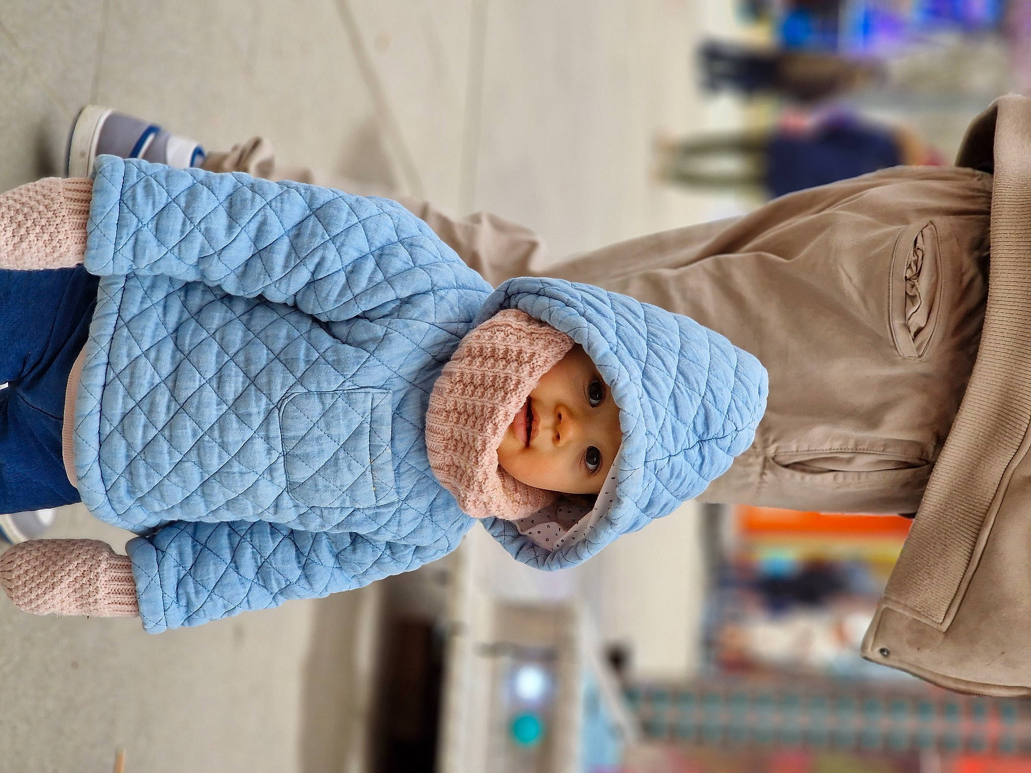 Mia participe au concours pour gagner de l'argent avec cette photo : beanie, cap, child, denim, electric_blue, fashion_accessory, fun, happy, headgear, headwear, jacket, joint, knit_cap, leisure, person, sitting, sleeve, textile, toddler, wood