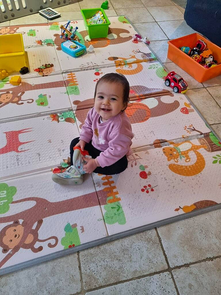 Mia a rejoint le concours — aidez-le/la à gagner de superbes lots ! art, baby, baby_toys, child, event, floor, flooring, fun, grass, happy, joy, leisure, pattern, person, play, playmat, room, smile, textile, toddler