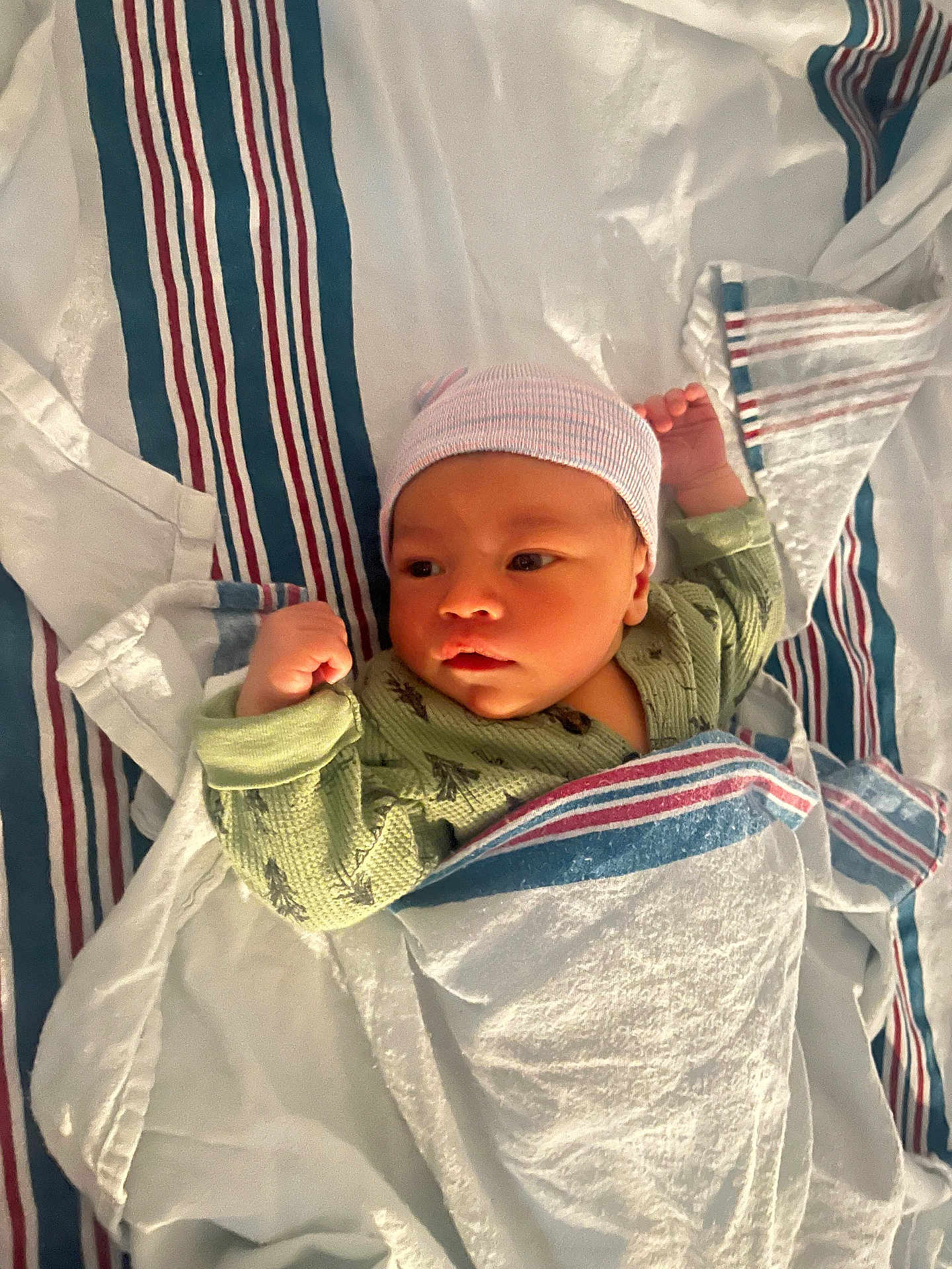 Keegan joined the competition — help win amazing prizes! baby, newborn, infant, blanket, hospital, hat, clothing, lying_down, striped, green_onesie, cute, face, skin, sleepwear, bed, comfort, child, portrait, newborn_hat, swaddled