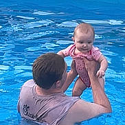 Nova joined the competition — help win amazing prizes! adult, baby, back, blue, child, fun, head, holding, outdoor, person, pink_clothing, play, short_hair, skin, sleeveless_shirt, summer, swimming_pool, toddler, water, wet_clothing
