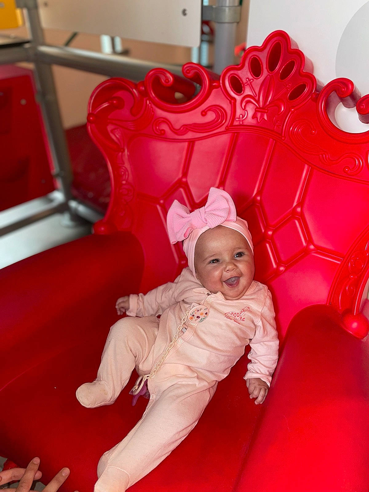 Inaya participe au concours pour gagner de l'argent avec cette photo : baby, baby_toddler_clothing, carmine, chair, child, comfort, flooring, font, fun, happy, headwear, leisure, magenta, person, pink, plastic, red, room, sitting, smile