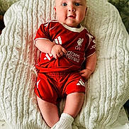 Cobe joined the competition — help win amazing prizes! baby, blue_eyes, child, chubby_cheeks, comfortable, couch, cozy, cute, football_kit, indoor, infant, knitted_blanket, liverpool_fc, person, portrait, red_clothing, seated, smiling, soft_texture, white_socks