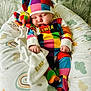 Cobe is registered to the contest to win money with this photo: baby, blanket, child, colorful_clothing, cozy, cushion, cute, face, hat, indoors, infant, multicolor, nap, patchwork, pattern, person, resting, sleeping, soft_toys, stuffed_toy