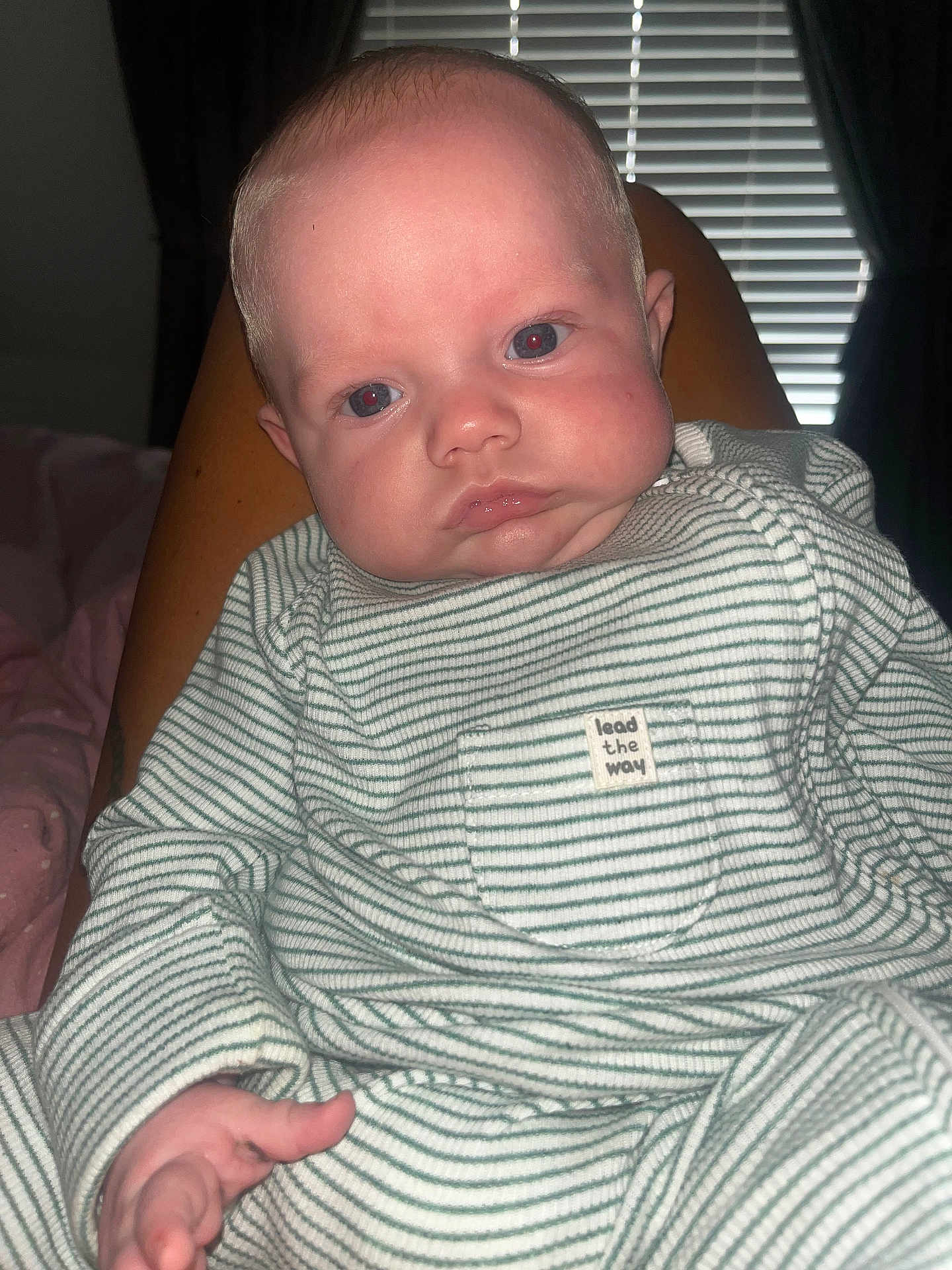 Vinnie joined the competition — help win amazing prizes! baby, infant, face, person, striped_clothing, onesie, hand, legs, indoor, window_blinds, curtains, red_eye, skin, expression, child, portrait, sitting, closeup, flash_photography, home