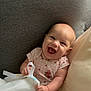 baby, smiling, happy, infant, torn_paper, cushion, sofa, clothing, onesie, cheerful, face, person, sitting, indoors, cute, playful, skin, head, expression, small_hands