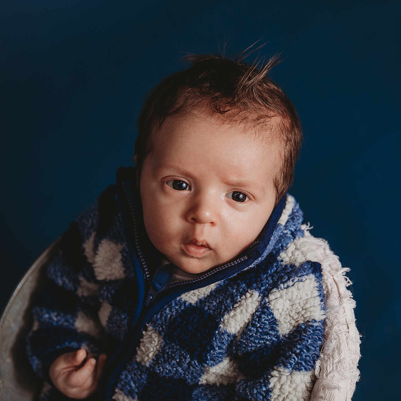 Brevon joined the competition — help win amazing prizes! baby, blanket, blue_background, child, close_up, cozy, cute, expression, eyes, face, hair, infant, looking_at_camera, portrait, seat, sherpa_jacket, studio_lighting, texture, warm_clothing, young