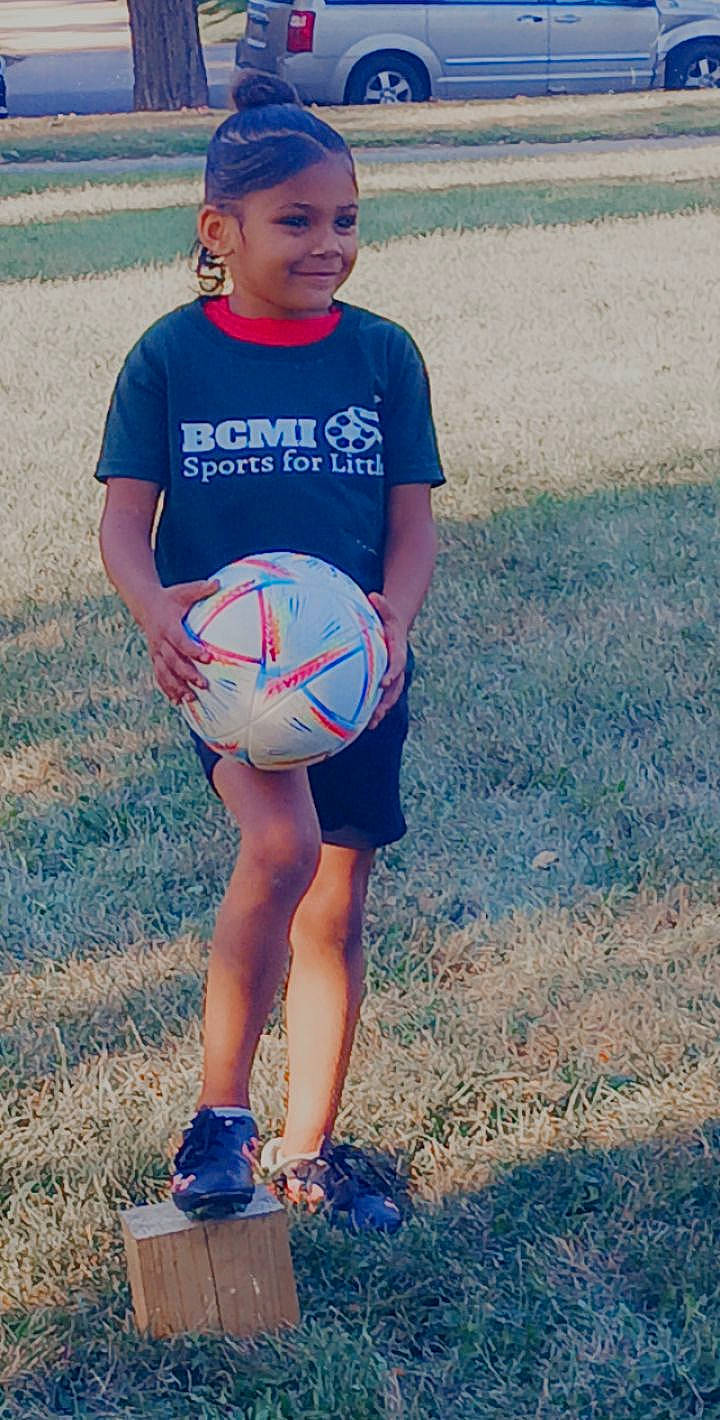 Paris is registered to the contest to win money with this photo: azure, ball, ball_game, football, grass, happy, human_body, joy, knee, leisure, morning, people_in_nature, person, player, playing_sports, shorts, shoulder, sneakers, soccer_ball, sports_equipment