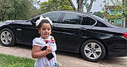 Monserrat joined the competition — help win amazing prizes! child, girl, white_dress, embroidery, smartphone, sidewalk, grass, car, black_car, tree, outdoor, summer, shoes, sandals, house, residential_area, nature, daylight, portrait, cute