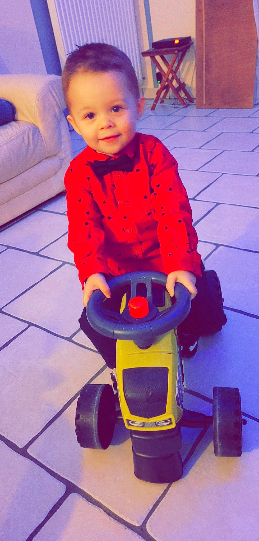 Mayron participe au concours pour gagner de l'argent avec cette photo : baby, baby_toddler_clothing, blue, face, floor, flooring, fun, happy, orange, person, photograph, purple, red, riding_toy, sleeve, smile, tire, toddler, wheel, white