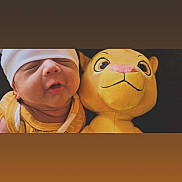 Cristian is registered to the contest to win money with this photo: newborn, baby, infant, child, portrait, sleepy, white_hat, plush_toy, lion, stuffed_animal, yellow, cuddling, close_up, face, indoors, warm_lighting, onesie, infant_clothing, photography, cozy