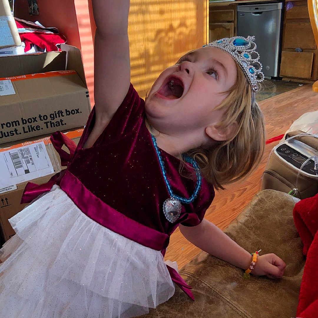 Jazmine is registered to the contest to win money with this photo: accessories, child, clothing, costume, crown, dress, face, female, food, furniture, girl, head, jewelry, necklace, person, photography, portrait, skirt, sweets, yawning