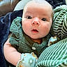baby, blanket, child, closeup, clothing, cozy, cute, expression, face, floral, green, indoors, infant, mittens, newborn, pattern, person, portrait, soft, striped