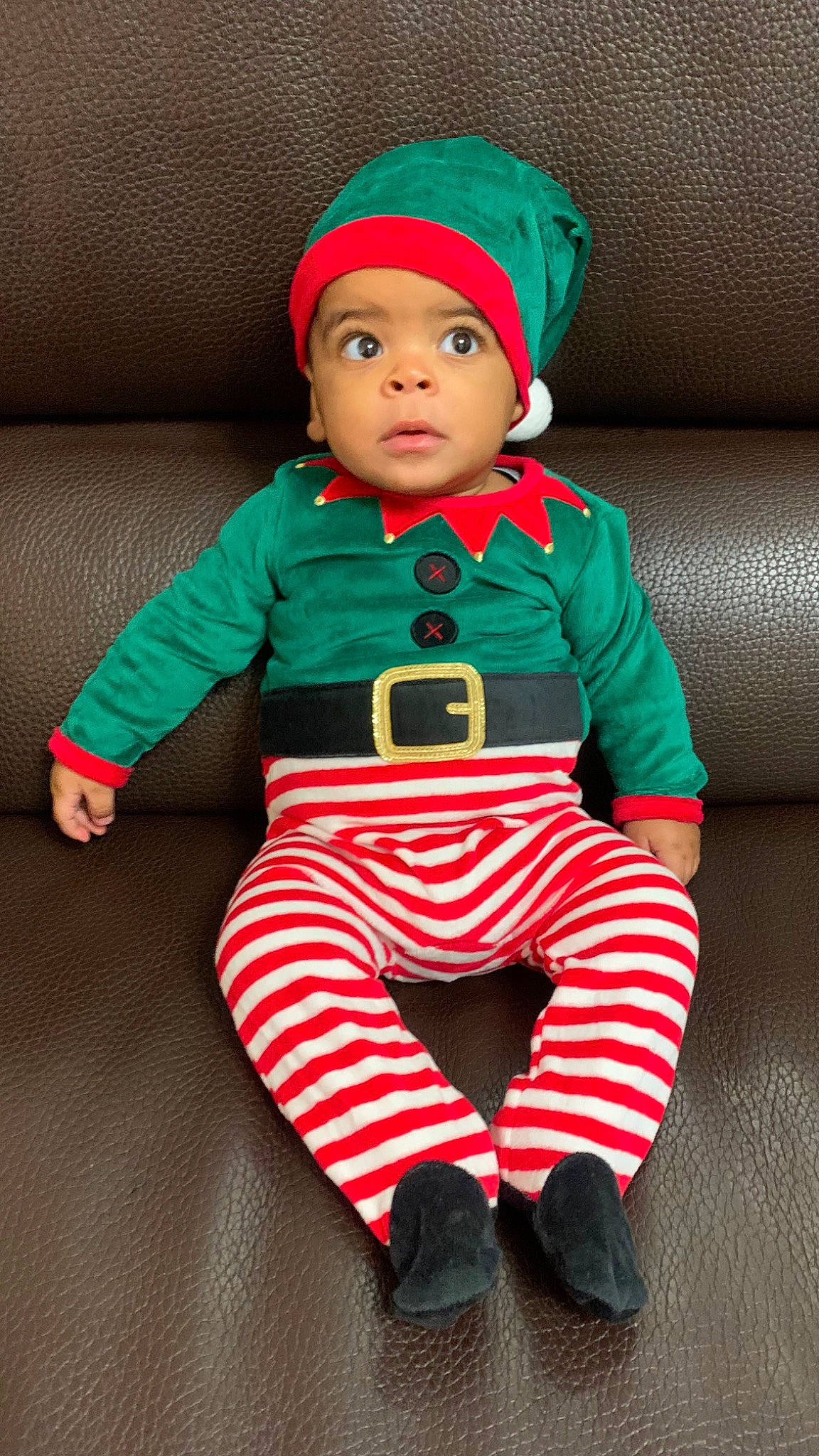 Lyham participe au concours pour gagner de l'argent avec cette photo : baby, baby_toddler_clothing, cap, child, costume_hat, couch, face, fictional_character, green, head, headgear, headwear, holiday, linens, outerwear, person, red, sitting, sleeve, t_shirt