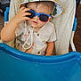 Loukas participe au concours pour gagner de l'argent avec cette photo : baby, blue_tray, casual, child, clothing, curious, cute, expression, face, furniture, hand, hat, high_chair, indoor, person, seat, storage_boxes, sunglasses, toddler, wooden_floor