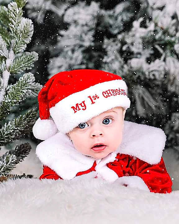 Kash is registered to the contest to win money with this photo: baby, baby_toddler_clothing, cap, child, christmas, christmas_eve, conifer, costume_hat, event, face, freezing, happy, hat, headgear, headwear, holiday, pattern, person, sleeve, snow