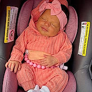 Kaleesi Rose is registered to the contest to win money with this photo: newborn, baby, sleeping, infant, car_seat, pink, coral, bow, hat, outfit, socks, blanket, portrait, face, closed_eyes, resting, indoors, vehicle, child, photograph