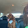 back_seat, bandana, birthday, car_interior, dog, golden_retriever, green_shirt, happy, headrest, leash, person, pet, road, seat, sunlight, tongue_out, travel, trees, vehicle, window