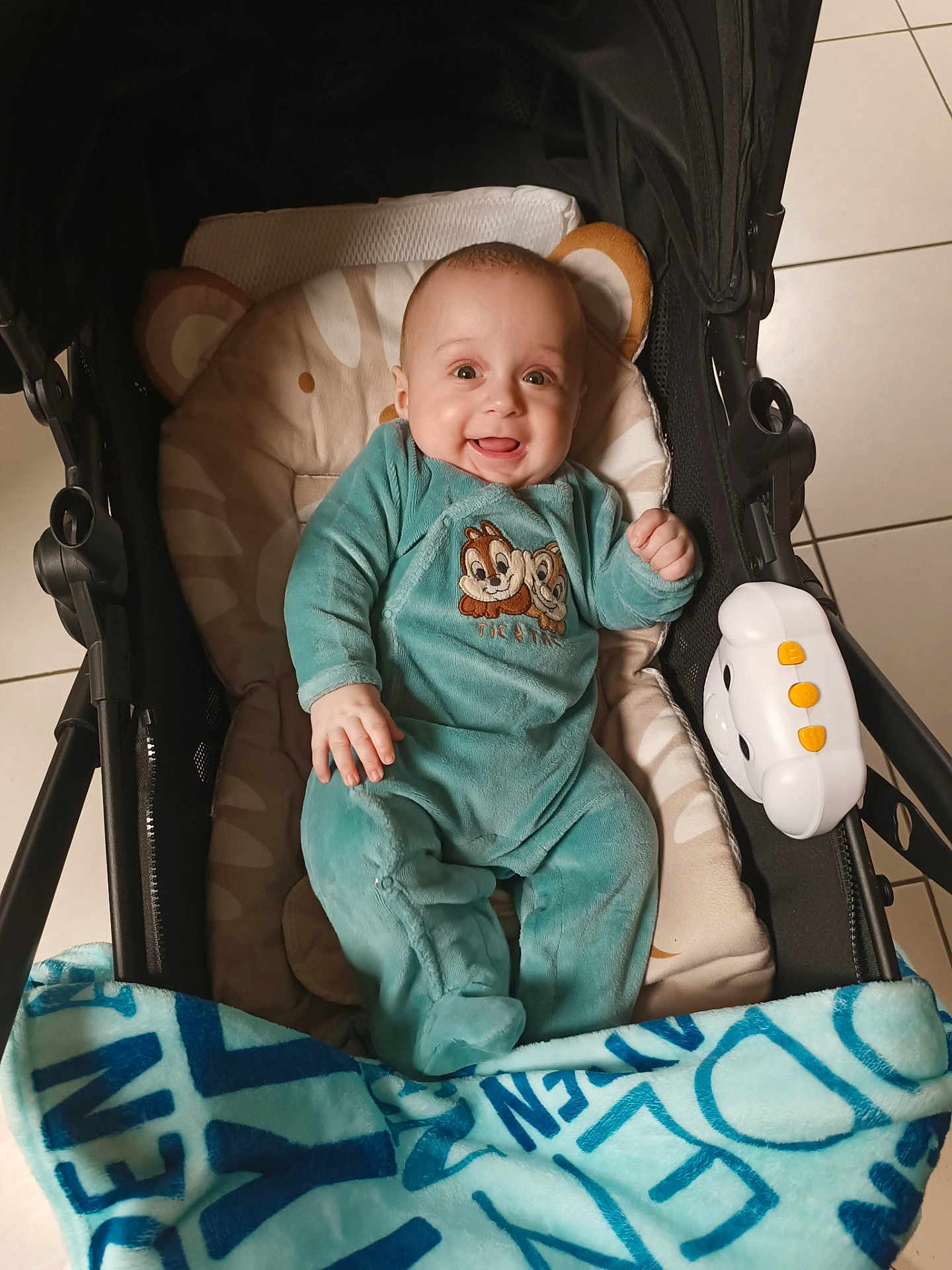 Ayden participe au concours pour gagner de l'argent avec cette photo : baby, infant, stroller, blanket, pajamas, smile, toy, tiled_floor, seat, portrait, indoor, happy, hand, eyes, head, cute, clothing, plush, person, baby_blanket