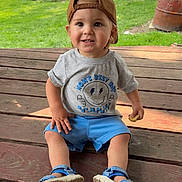 Russell joined the competition — help win amazing prizes! toddler, child, boy, cap, brown_cap, gray_tshirt, blue_shorts, blue_sandals, cookie, wooden_floor, porch, outdoor, grass, tree, smiling, sitting, casual_clothing, daylight, nature, happy