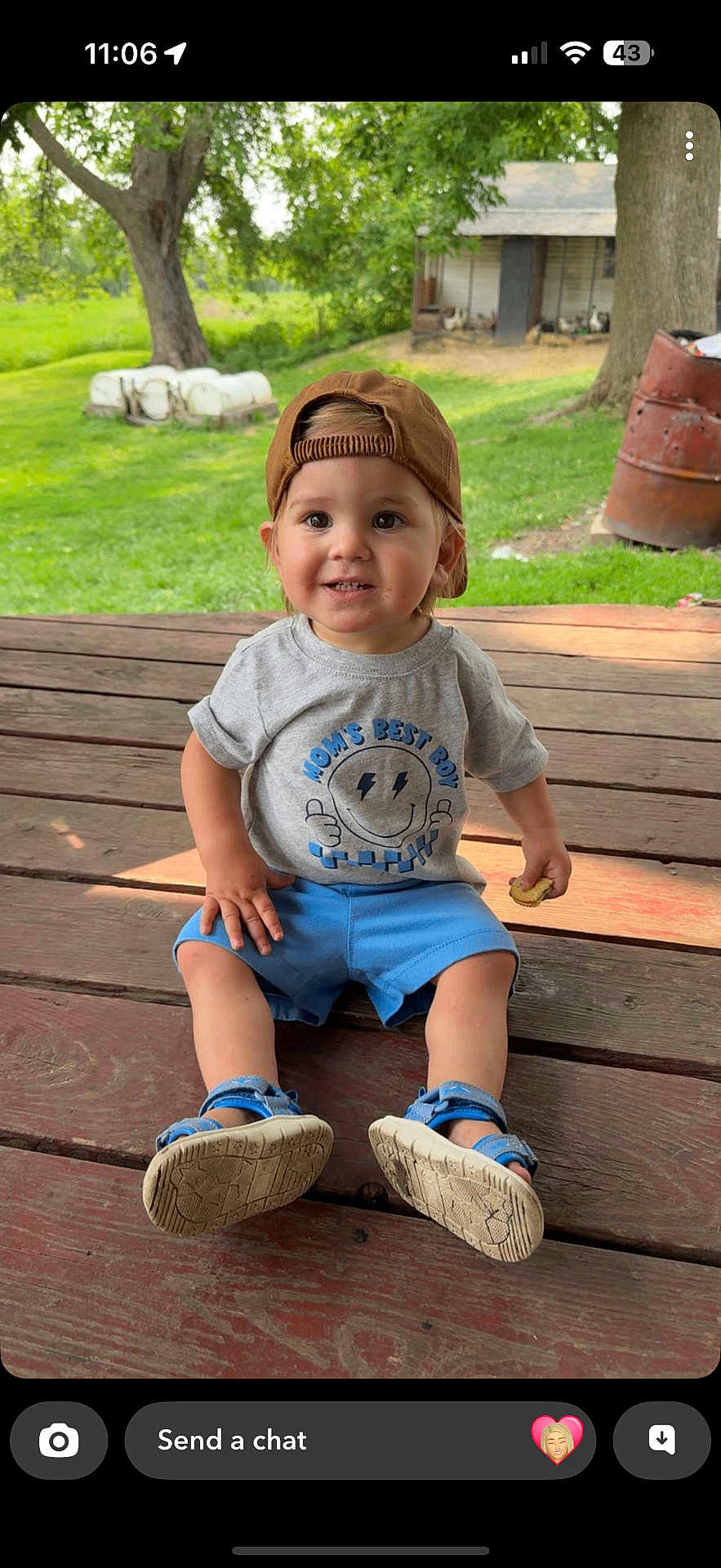Russell joined the competition — help win amazing prizes! toddler, child, boy, cap, brown_cap, gray_tshirt, blue_shorts, blue_sandals, cookie, wooden_floor, porch, outdoor, grass, tree, smiling, sitting, casual_clothing, daylight, nature, happy