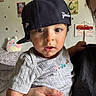toddler, child, baby, cap, hat, face, person, indoor, wall, poster, stars, hand, clothing, cute, expression, eyelashes, toy, plush, furniture, decor