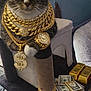 cat, tabby, cat_tree, jewelry, crown, sunglasses, gold_chain, watch, dollar_sign, stack_of_cash, gold_bars, indoor, pet, whiskers, paws, bling, accessory, portrait, luxury, funny