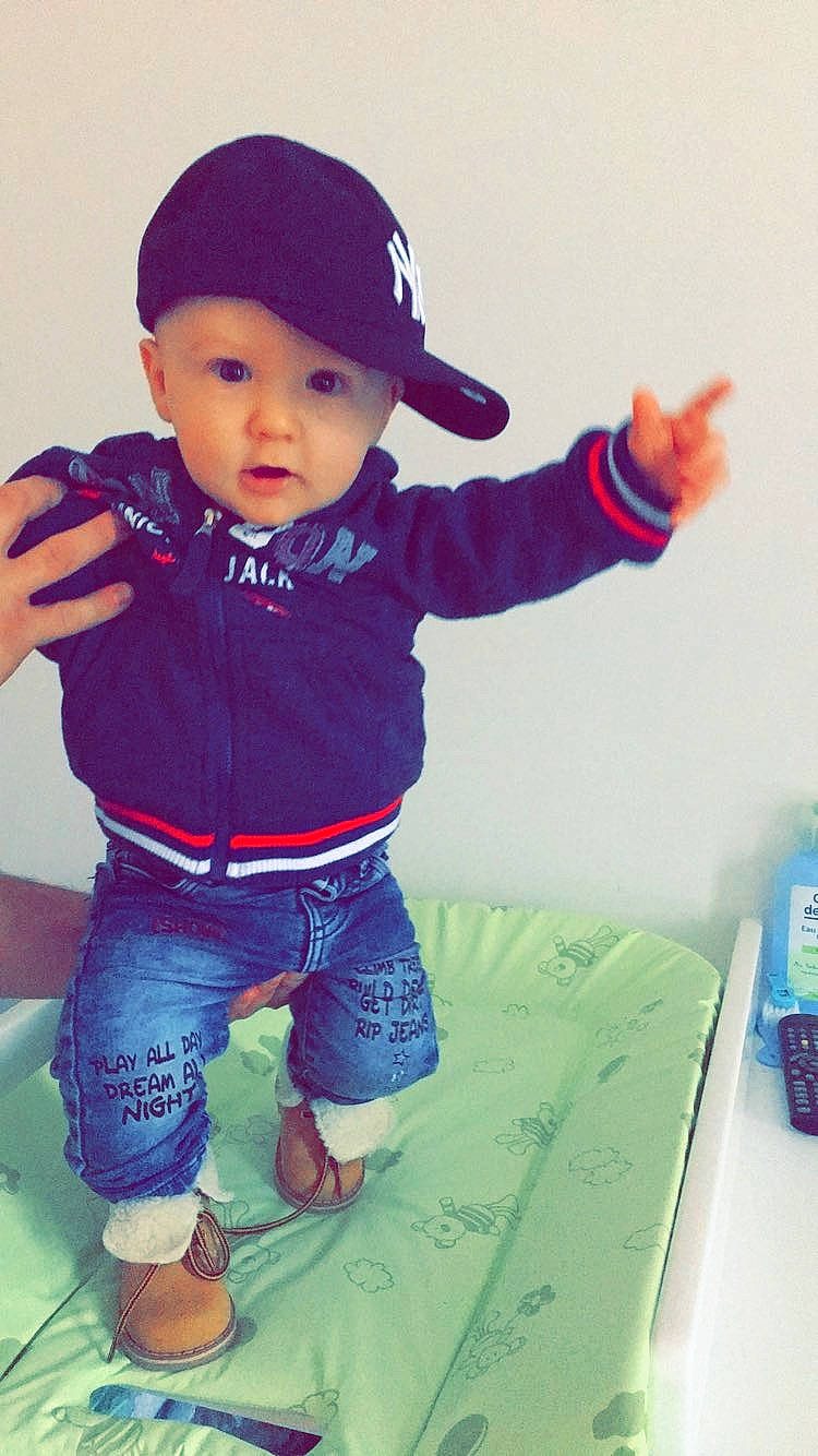 Lény participe au concours pour gagner de l'argent avec cette photo : baby, baby_products, baby_toddler_clothing, beanie, bonnet, cap, child, cool, denim, finger, headwear, jeans, mobile_phone, person, pocket, product, sleeve, sock, telephone, telephony