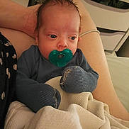 Alexander joined the competition — help win amazing prizes! baby, pacifier, blanket, clothing, infant, hand, person, sitting, indoor, face, head, skin, comfort, resting, adult, lap, fingers, cute, young, warm