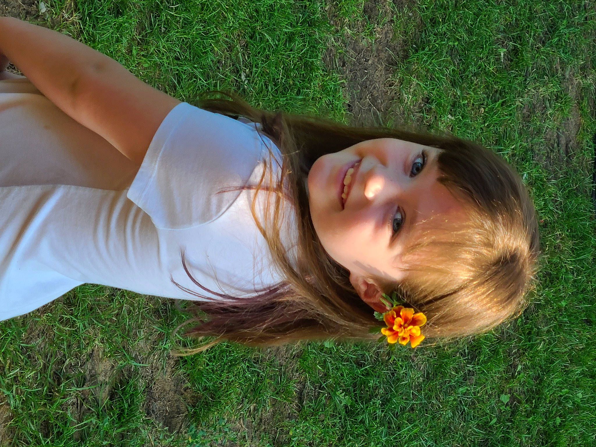 Stephanie is registered to the contest to win money with this photo: black_hair, blond, elbow, face, flower, fun, grass, grassland, hair, happy, joy, lawn, leisure, long_hair, meadow, natural_environment, people_in_nature, person, plant, smile