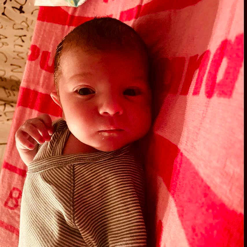 Ayden a rejoint le concours — aidez-le/la à gagner de superbes lots ! baby, blanket, closeup, curious, face, head, human, indoors, infant, lying_down, newborn, pampers, portrait, red, skin, small_hand, soft_lighting, striped_clothing, towel, wipes