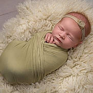 Orlagh is registered to the contest to win money with this photo: newborn, baby, swaddle, headband, flower, sleeping, blanket, soft_texture, infant, peaceful, portrait, closeup, cute, wrapped, resting, child, adorable, cozy, indoors, baby_photography