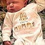 baby, newborn, sleeping, onesie, infant, cute, child, peaceful, cushion, deer_pattern, leaf_pattern, soft, cozy, face, hand, footed_pajamas, indoor, portrait, rest, adorable