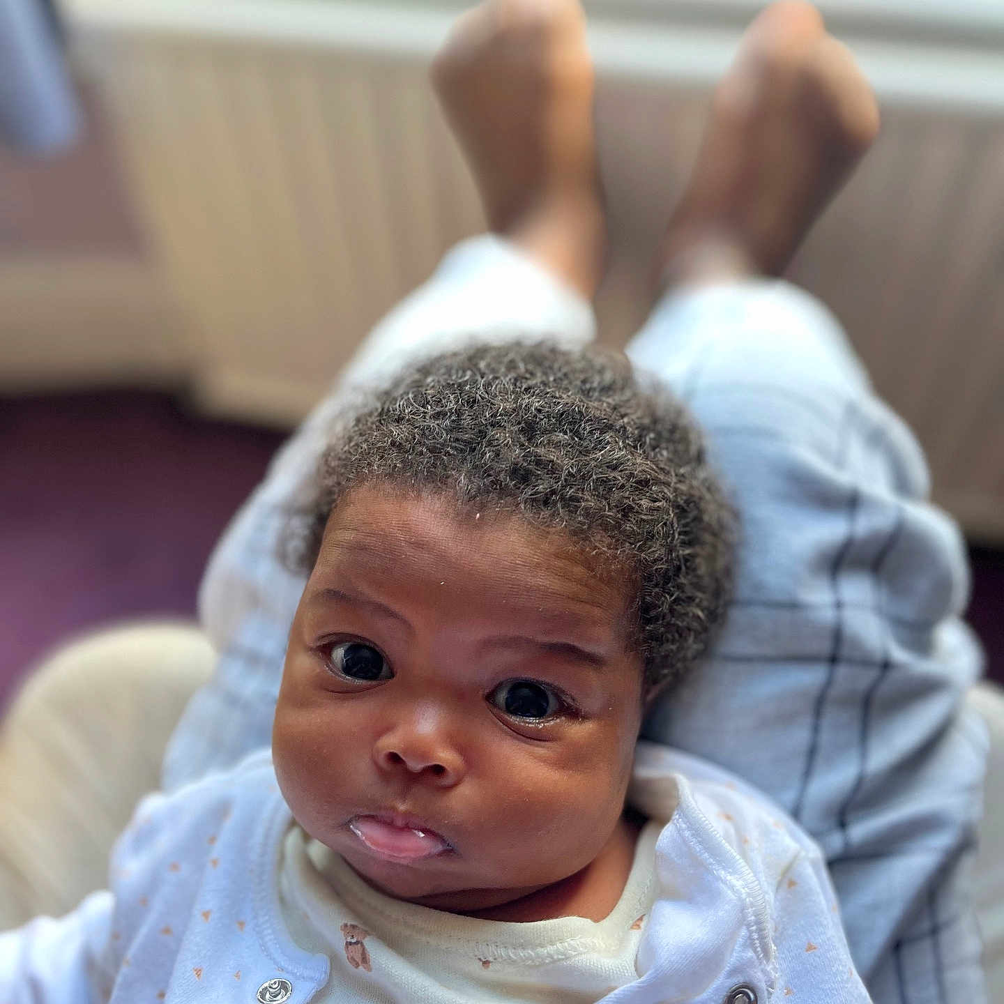 Calista is registered to the contest to win money with this photo: baby, blurred_background, child, cozy, curly_hair, cute, expression, eyes, face, indoor, infant, legs, newborn, person, portrait, pout, skin, soft_light, white_clothing, young