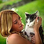 woman, cat, pet, outdoor, greenery, portrait, animal, human, blonde_hair, holding, affection, nature, face, fur, whiskers, closeup, gentle, love, person, daylight