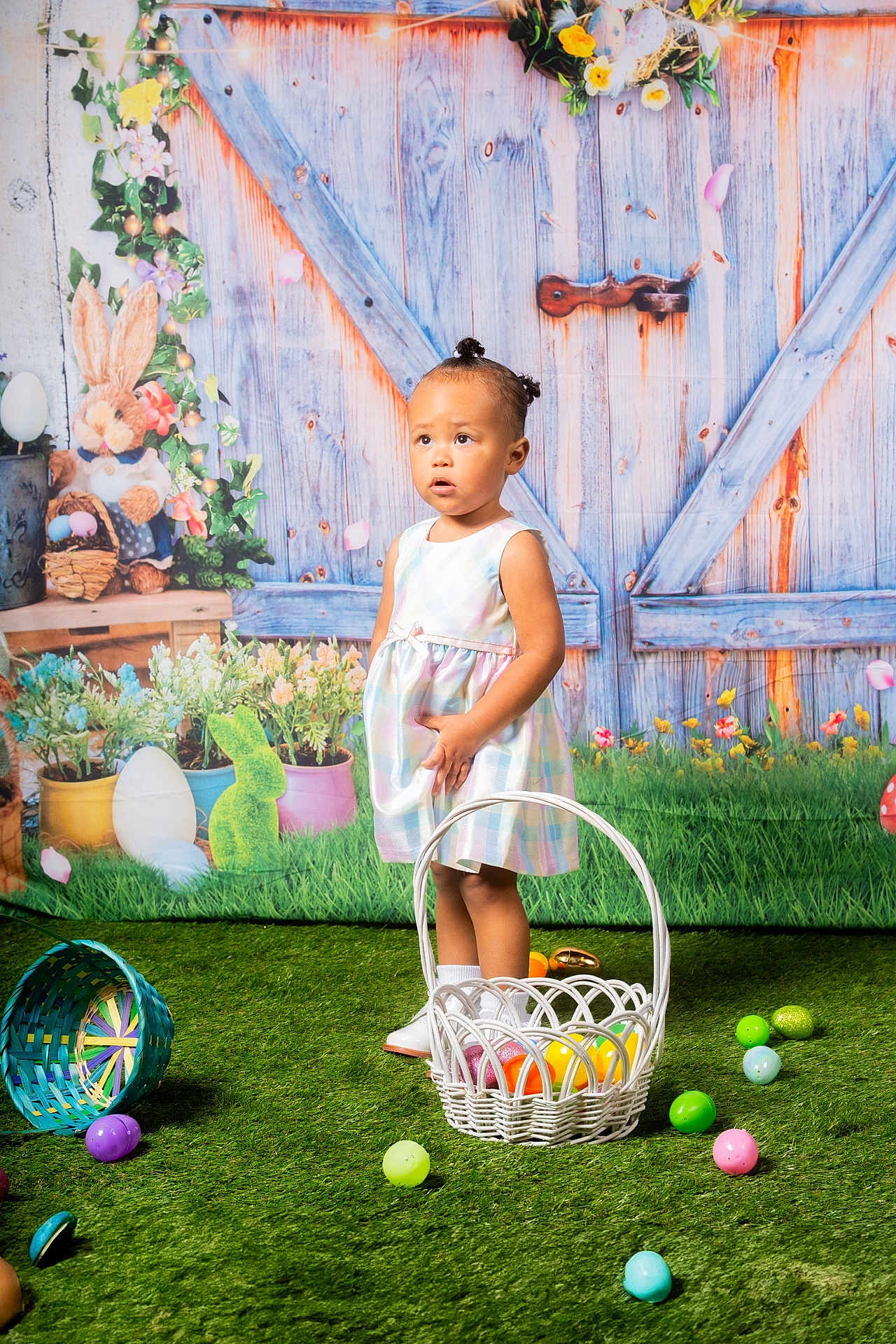 Layla is registered to the contest to win money with this photo: child, girl, easter_eggs, basket, grass, dress, hair_buns, flowers, decor, bunny, indoor, artificial_grass, colorful, toy, standing, curious, background, holiday, spring, portrait