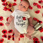 Danny joined the competition — help win amazing prizes! baby, infant, onesie, red_poppy, flower, cross, silver_cup, blanket, remembrance, lying_down, cute, portrait, child, soft_texture, peaceful, commemoration, memorial, hands, legs, skin