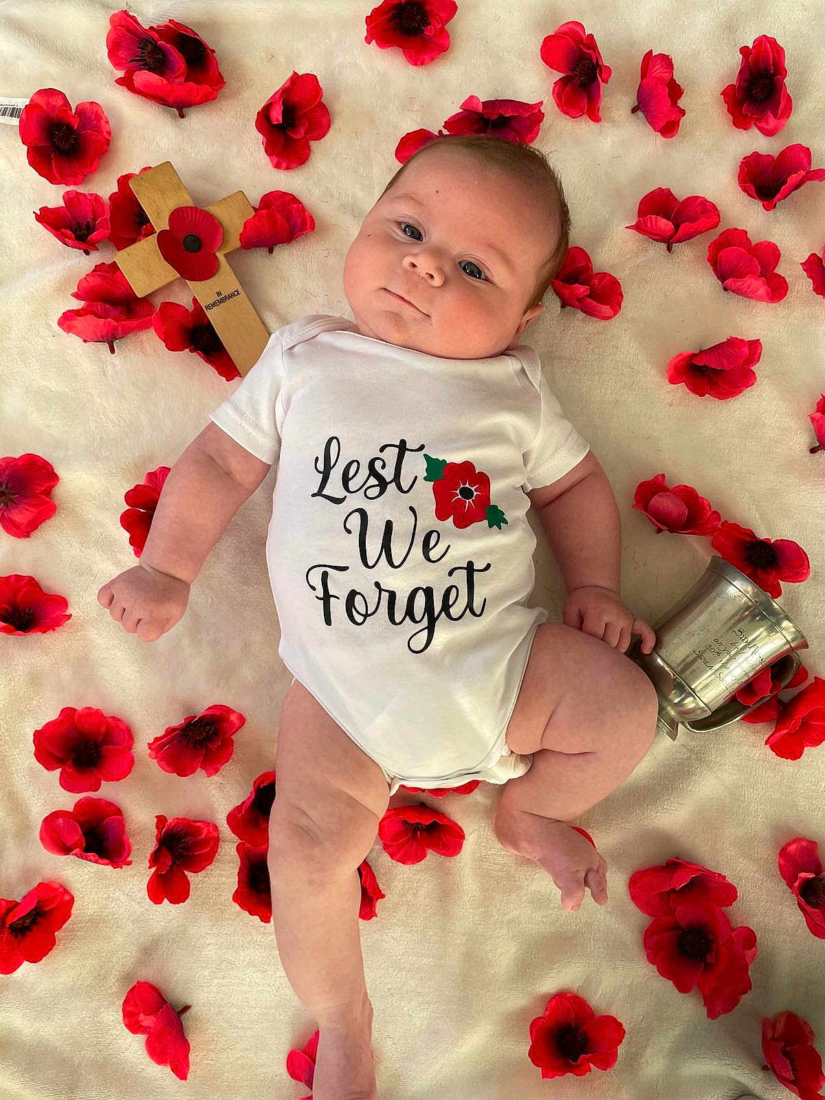 Danny joined the competition — help win amazing prizes! baby, infant, onesie, red_poppy, flower, cross, silver_cup, blanket, remembrance, lying_down, cute, portrait, child, soft_texture, peaceful, commemoration, memorial, hands, legs, skin