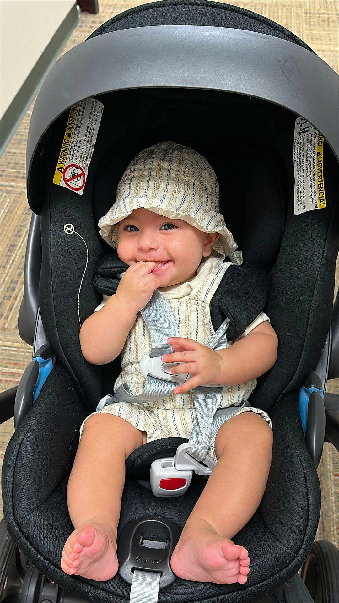 Andrew joined the competition — help win amazing prizes! baby, car_seat, smiling, hat, clothing, infant, stripes, sitting, child, footwear, barefoot, happy, safety_harness, indoor, cute, person, fingers, playful, seat, expression