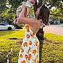 Andrew is registered to the contest to win money with this photo: woman, baby, child, outdoor, sunlight, tree, grass, side_view, smile, dress, pattern, car, road, nature, happy, holding, footwear, person, family, summer