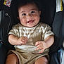 baby, smiling, car_seat, striped_shirt, shorts, child, happy, infant, person, clothing, seatbelt, indoor, cute, young_child, baby_face, playful, hands, casual_wear, seat, adorable