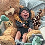 Andrew is registered to the contest to win money with this photo: baby, infant, smiling, plush_toy, teddy_bear, giraffe, dinosaur, sock, blanket, onesie, cape, cozy, cute, happy, child, soft_toy, indoor, portrait, sitting, playful