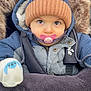 baby, blanket, blue, bundle, child, cold_weather, cute, face, fur_trim, glove, hat, infant, jacket, outdoor, pacifier, pink, portrait, stroller, warm, winter_clothing