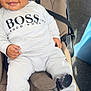 Drayton-Reign is registered to the contest to win money with this photo: baby, child, smiling, white_clothing, sneakers, stroller, seatbelt, curly_hair, drool, happy, indoors, person, cute, fashion, footwear, infant, casual, comfortable, portrait, seat